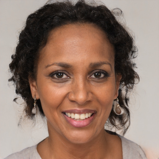 Joyful black adult female with medium  brown hair and brown eyes