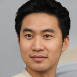 Joyful asian young-adult male with short  brown hair and brown eyes