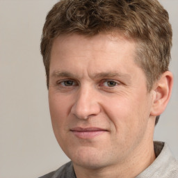 Joyful white adult male with short  brown hair and grey eyes