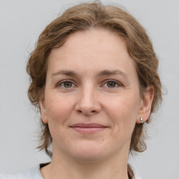 Joyful white adult female with medium  brown hair and grey eyes