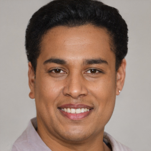 Joyful latino young-adult male with short  black hair and brown eyes
