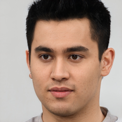 Joyful latino young-adult male with short  black hair and brown eyes