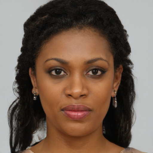 Joyful black young-adult female with long  brown hair and brown eyes
