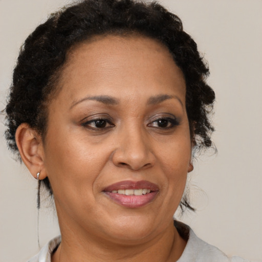 Joyful latino adult female with medium  brown hair and brown eyes