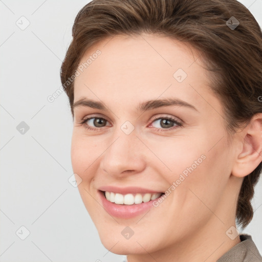 Joyful white young-adult female with medium  brown hair and grey eyes