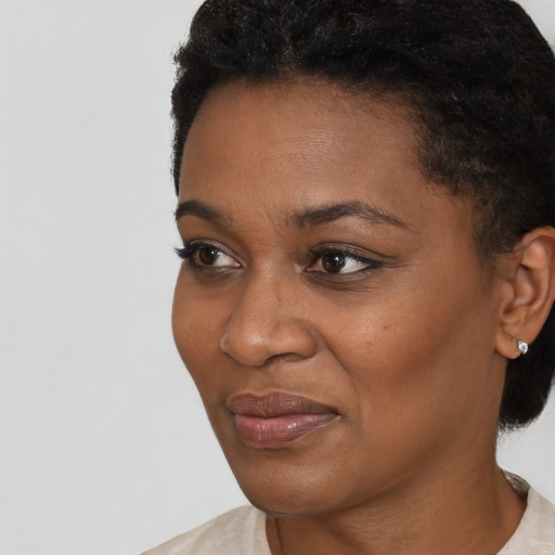 Joyful black young-adult female with short  black hair and brown eyes