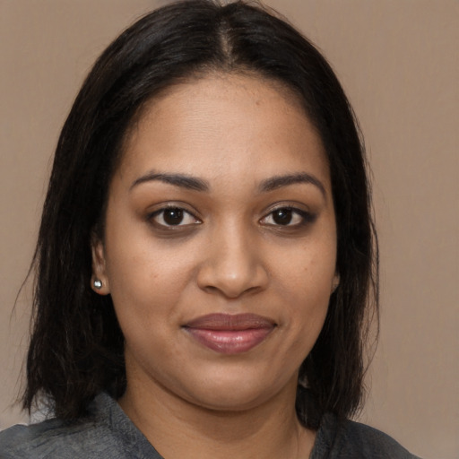 Joyful black young-adult female with long  brown hair and brown eyes