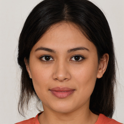 Joyful latino young-adult female with medium  brown hair and brown eyes