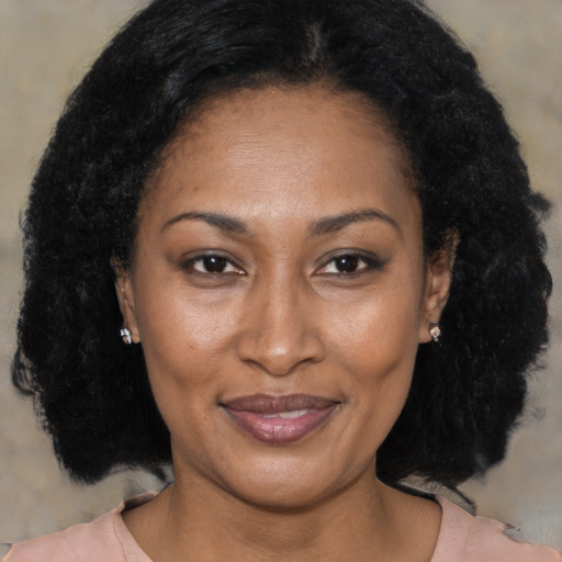 Joyful black adult female with medium  brown hair and brown eyes