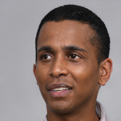 Joyful black young-adult male with short  black hair and brown eyes