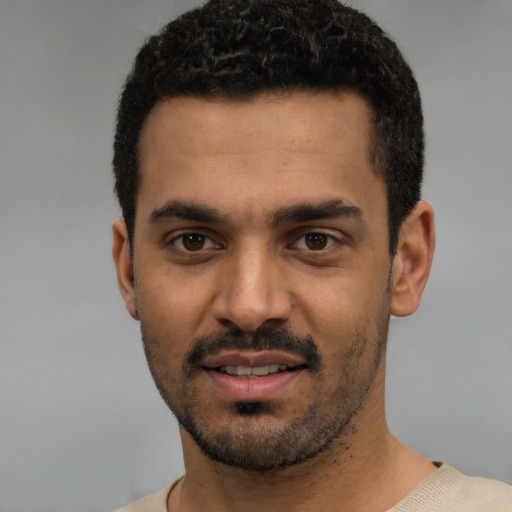 Joyful white young-adult male with short  black hair and brown eyes