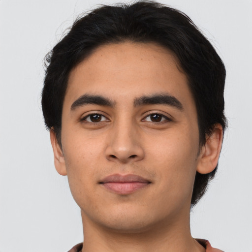 Joyful latino young-adult male with short  black hair and brown eyes