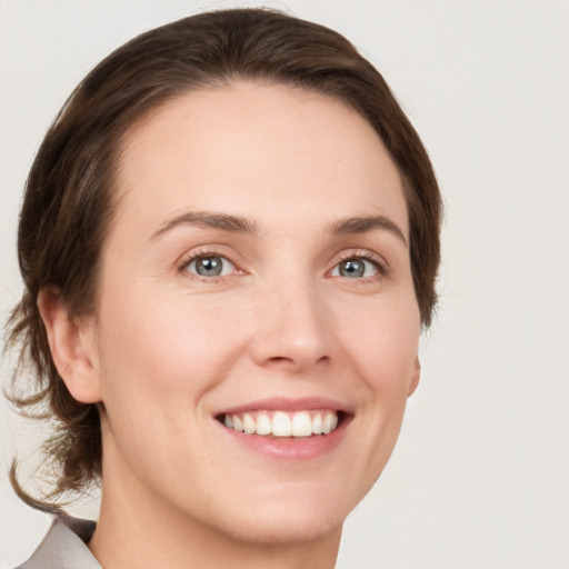 Joyful white young-adult female with medium  brown hair and green eyes