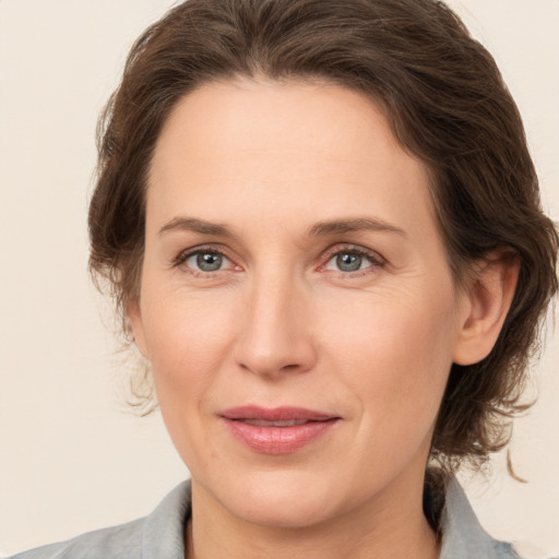 Joyful white adult female with medium  brown hair and grey eyes