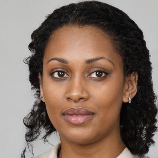 Joyful black young-adult female with long  black hair and brown eyes
