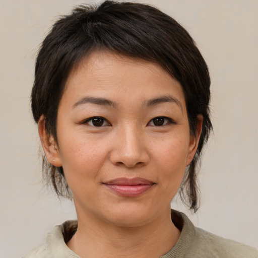 Joyful asian young-adult female with medium  brown hair and brown eyes