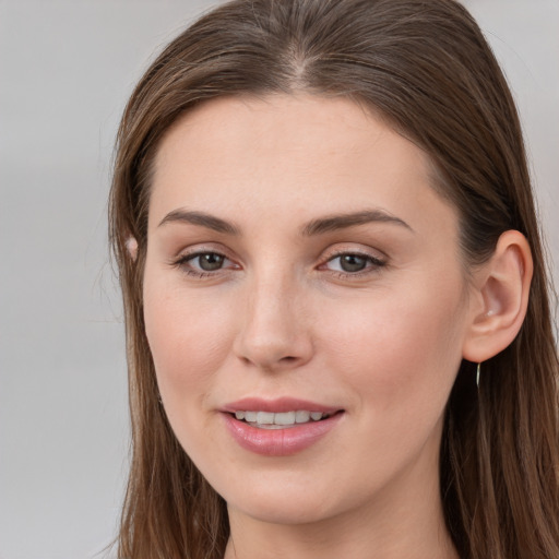 Joyful white young-adult female with long  brown hair and grey eyes