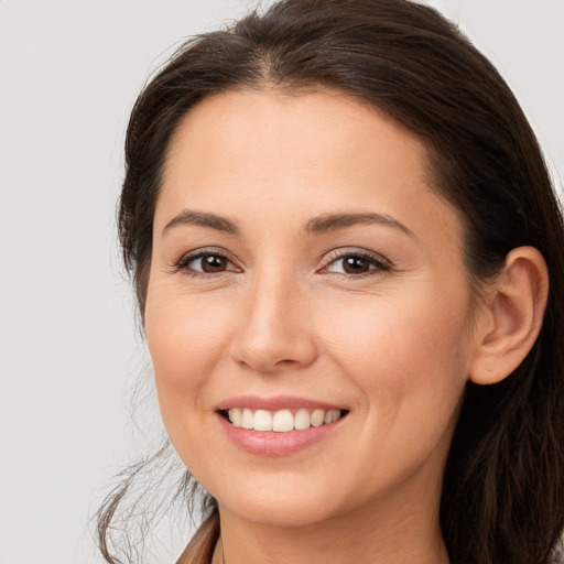 Joyful white young-adult female with long  brown hair and brown eyes