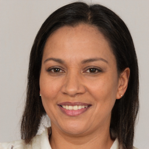 Joyful latino adult female with long  brown hair and brown eyes