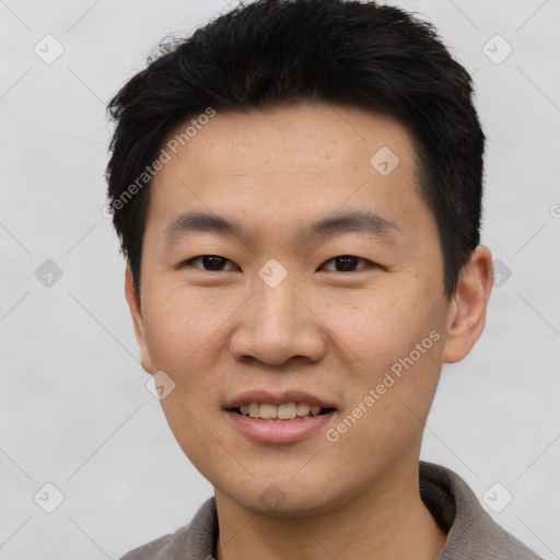 Joyful asian young-adult male with short  black hair and brown eyes