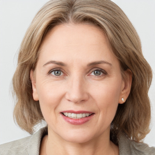 Joyful white adult female with medium  brown hair and grey eyes