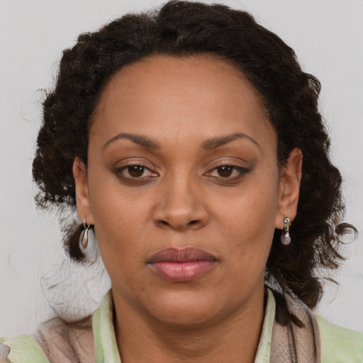 Joyful black adult female with medium  brown hair and brown eyes