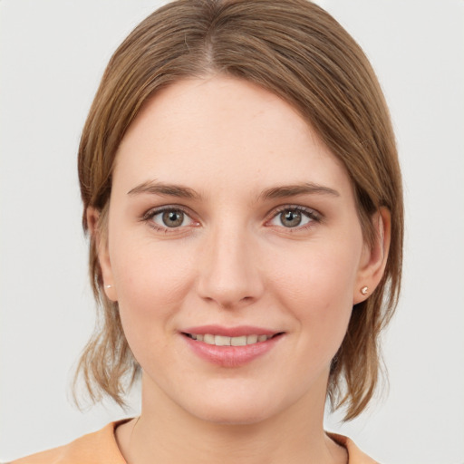 Joyful white young-adult female with medium  brown hair and grey eyes