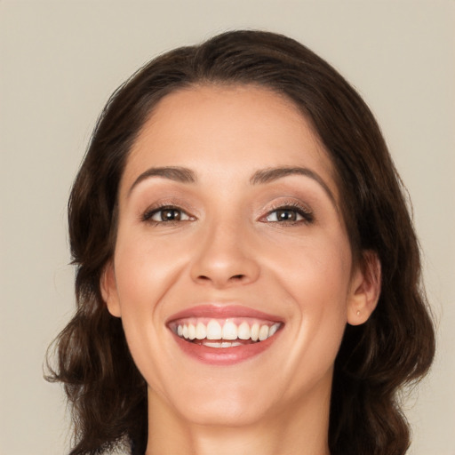 Joyful white young-adult female with long  brown hair and brown eyes