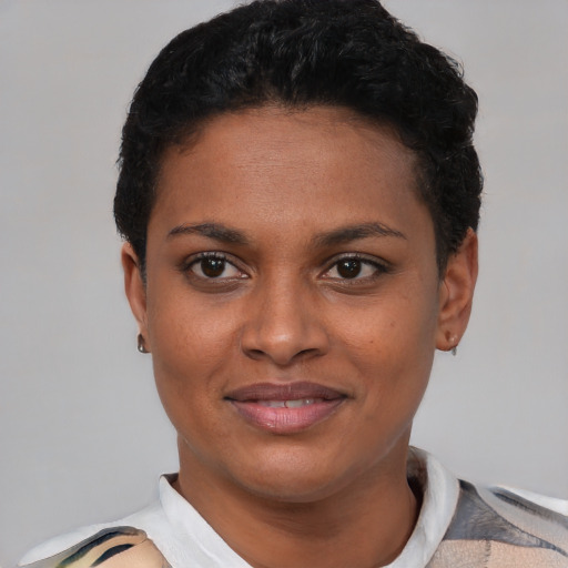 Joyful black young-adult female with short  black hair and brown eyes