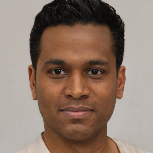 Joyful latino young-adult male with short  black hair and brown eyes