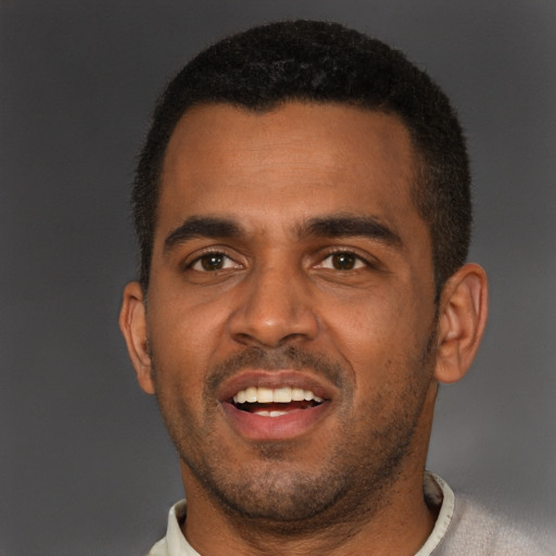 Joyful black young-adult male with short  brown hair and brown eyes