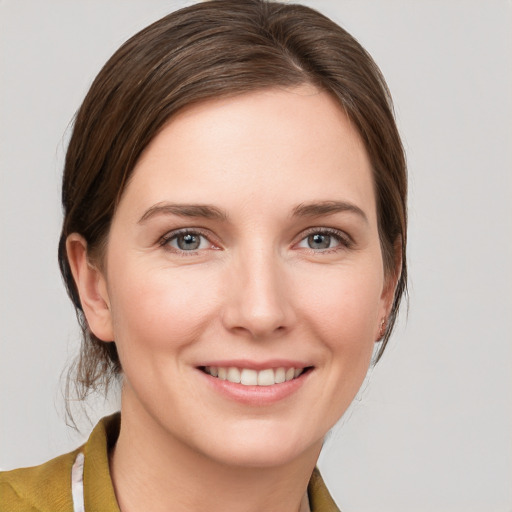 Joyful white young-adult female with medium  brown hair and grey eyes