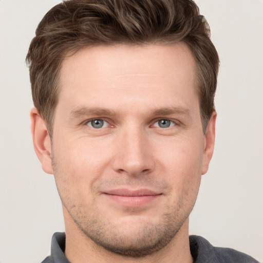 Joyful white young-adult male with short  brown hair and grey eyes