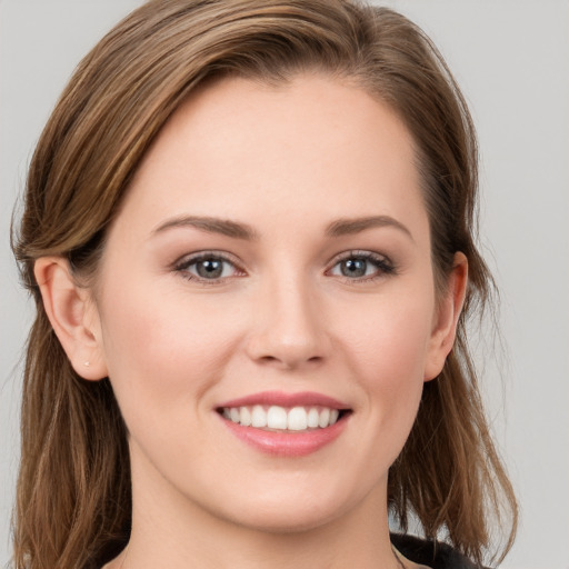 Joyful white young-adult female with long  brown hair and grey eyes