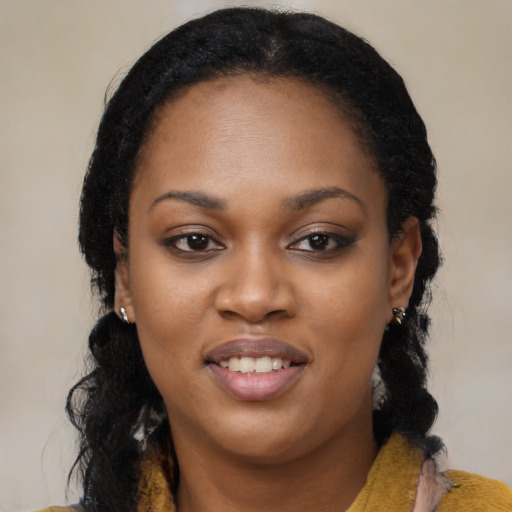 Joyful black young-adult female with long  black hair and brown eyes