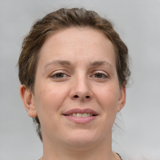 Joyful white young-adult female with short  brown hair and grey eyes