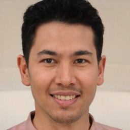 Joyful latino young-adult male with short  brown hair and brown eyes