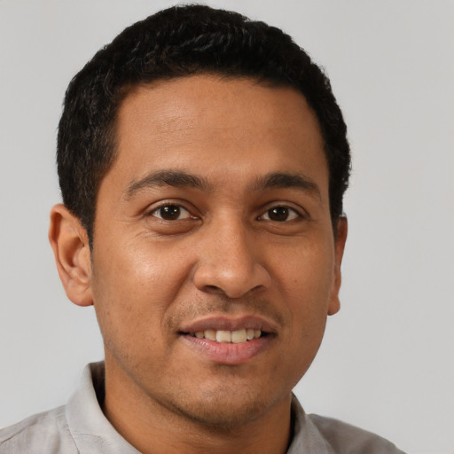 Joyful latino young-adult male with short  black hair and brown eyes