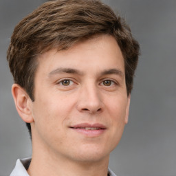 Joyful white young-adult male with short  brown hair and grey eyes