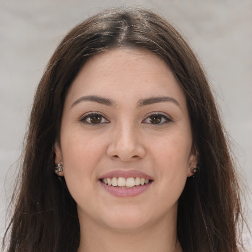 Joyful white young-adult female with long  brown hair and brown eyes