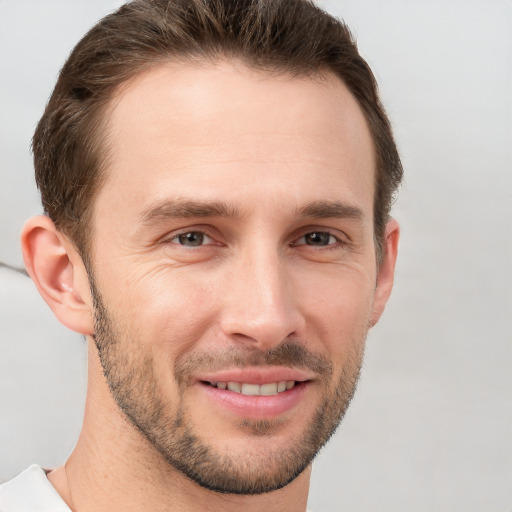 Joyful white young-adult male with short  brown hair and grey eyes