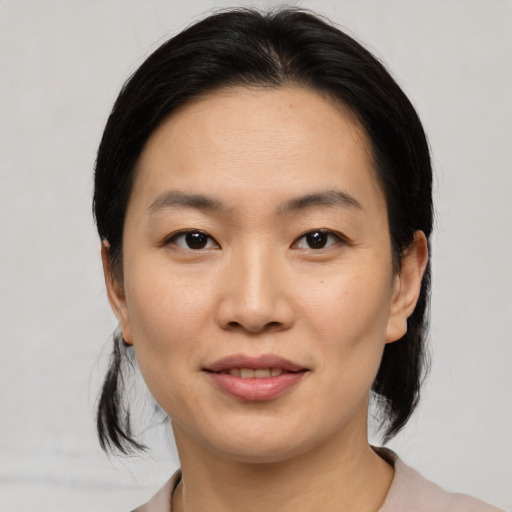 Joyful asian young-adult female with medium  black hair and brown eyes