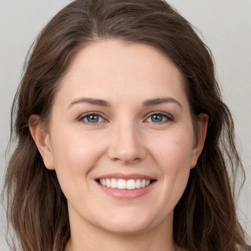 Joyful white young-adult female with long  brown hair and grey eyes