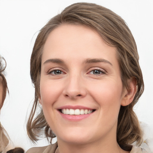 Joyful white young-adult female with medium  brown hair and grey eyes