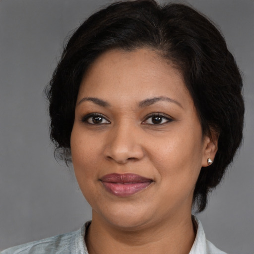 Joyful latino adult female with medium  brown hair and brown eyes