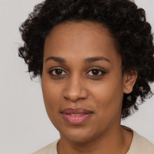 Joyful black young-adult female with short  brown hair and brown eyes