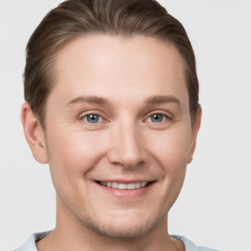 Joyful white young-adult male with short  brown hair and grey eyes