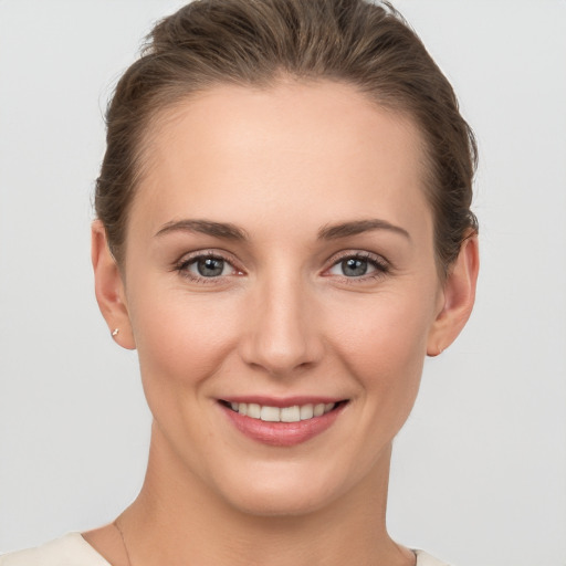 Joyful white young-adult female with short  brown hair and grey eyes