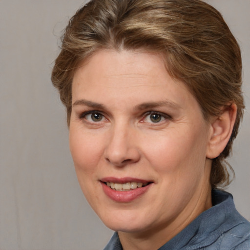 Joyful white adult female with medium  brown hair and blue eyes