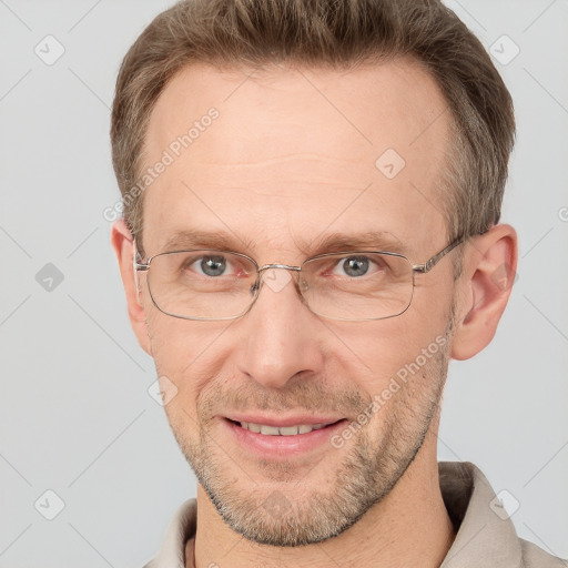 Joyful white adult male with short  brown hair and grey eyes